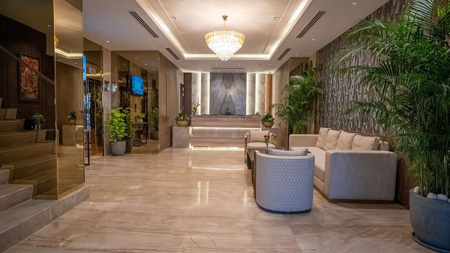 Reception desk with modern design, lighting, plants and seating area at ASTER GRAND BY ZENQ SAKET.