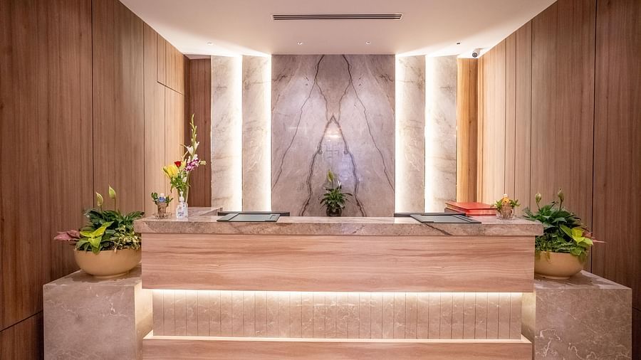 Reception desk with modern design, lighting and nicely arranged plants at ASTER GRAND BY ZENQ SAKET.