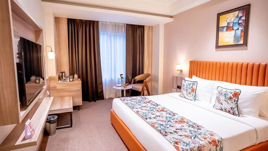 Superior Room at ASTER GRAND BY ZENQ SAKET with a bed, bed side table, TV, a chair and a window with curtain in the background.