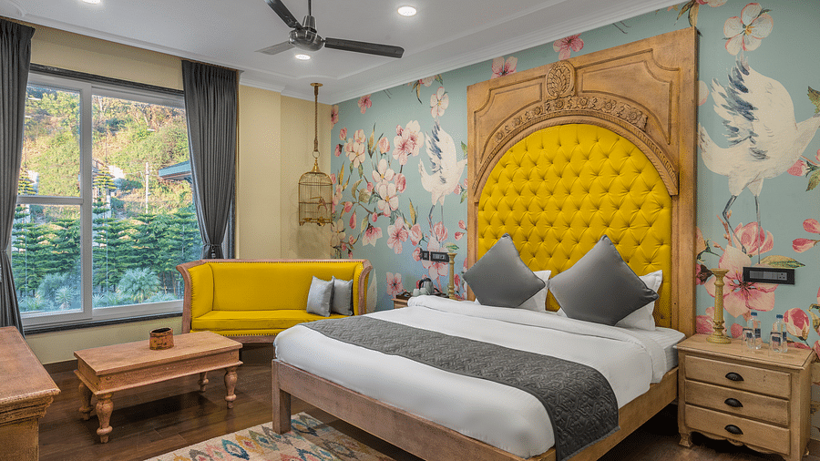 a bedroom with a large bed with a headrest and a sofa beside it - Atman, Dharamshala