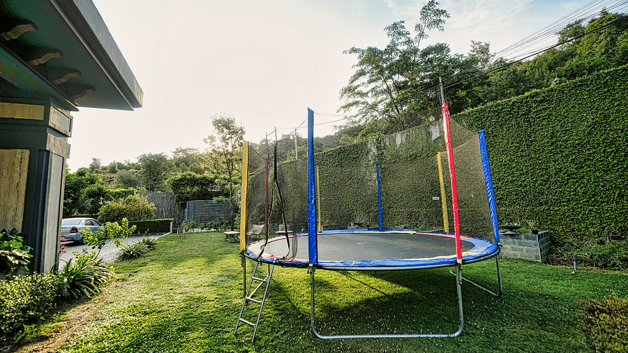 A close-up picture of a trampoline placed in lawn, captured in a day light.