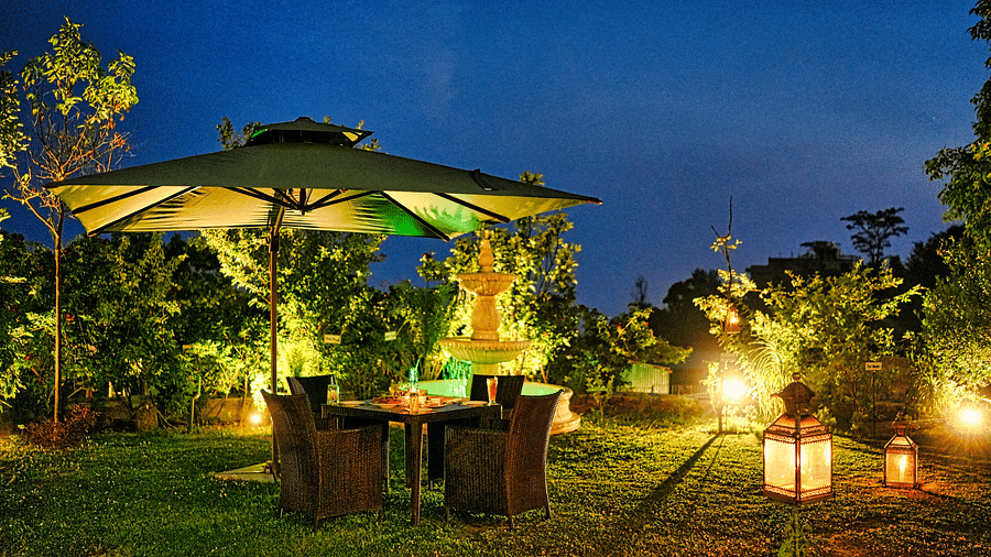 A cozy outdoor seating area with umbrellas and string lights - Atman, dharamshala