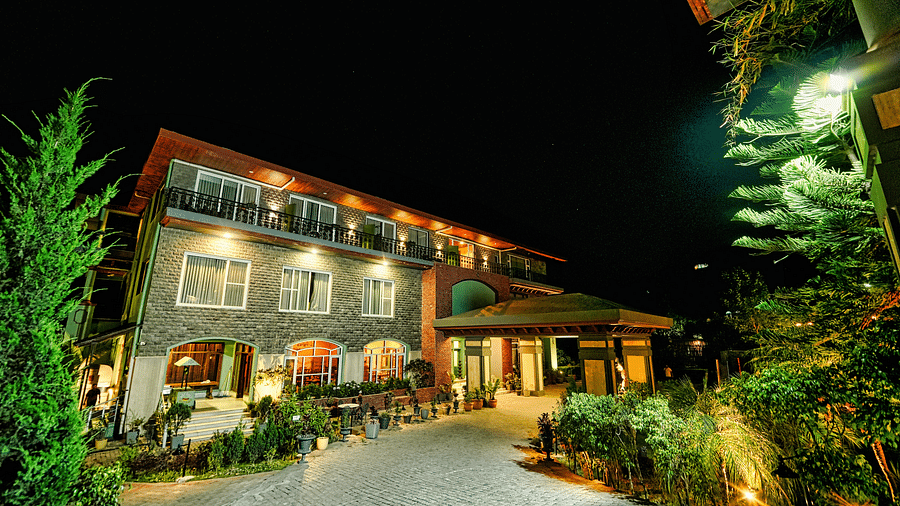 A picture of Atman, Dharamshala luxurious entrance with beautifully lit lighting and lawn area