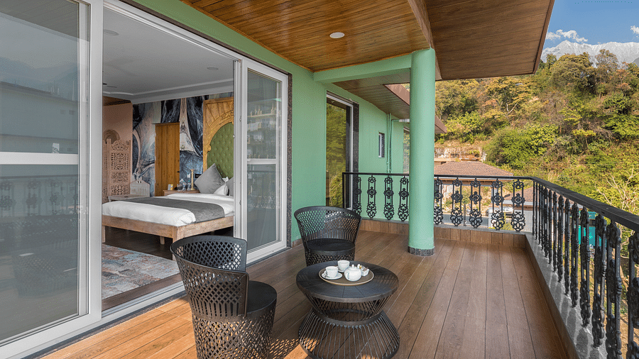 a balcony with a small table and chairs for sitting - Atman, Dharamshala