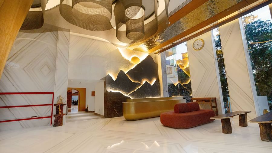 Image of a reception with a seating area and glass walls on the side at Auradoon, Dehradun.