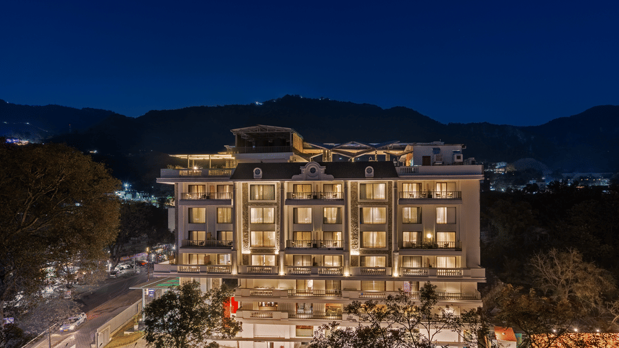 The night view of facade of Auradoon, Dehradun with mountains in the backdrop.