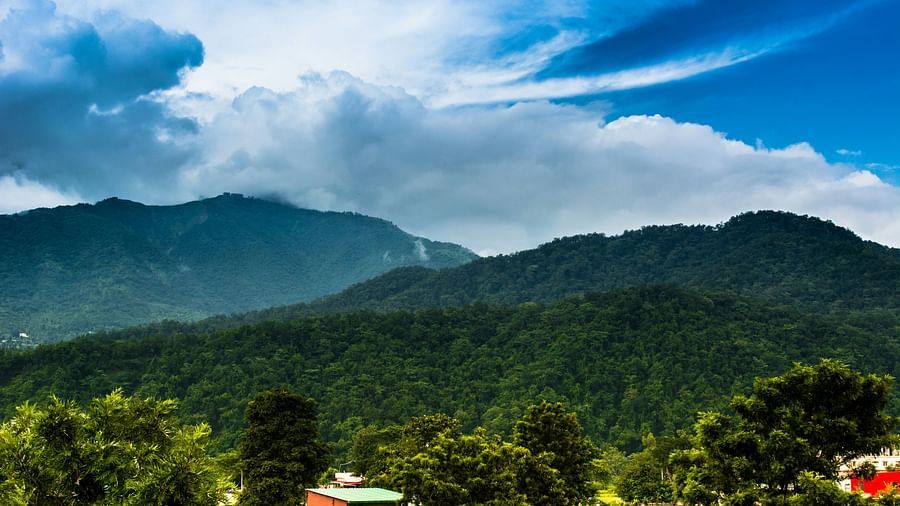 A wide view of mountains with a sky with scattered clouds in the background