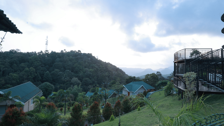 Full view of the lush green landscape with distant mountain valleys from Aveda Mountains and Mist Resort and Spa, Munnar.