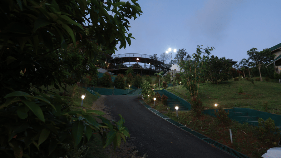 A gravel-filled pathway lined with exterior lights illuminating the pathway during the late evening hours at Aveda Mountains and Mist Resort and Spa, Munnar.