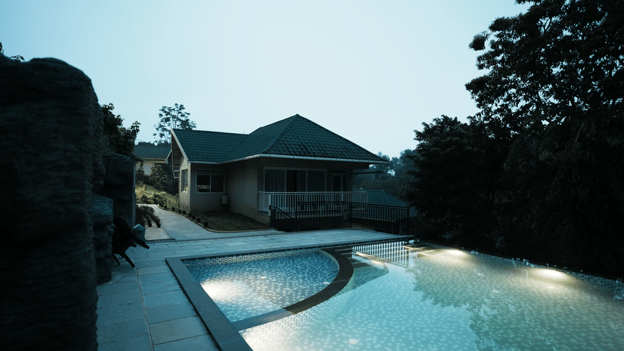 An outdoor swimming pool right beside the Luxe Mountain View Cottage during the late evening hours with a clear blue sky in the background.