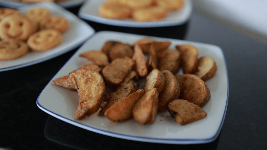 Close up of fried potato wedges along with several other fried fast food kept on a table at the Machaan restaurant at Aveda Mountains and Mist Resort and Spa, Munnar.
