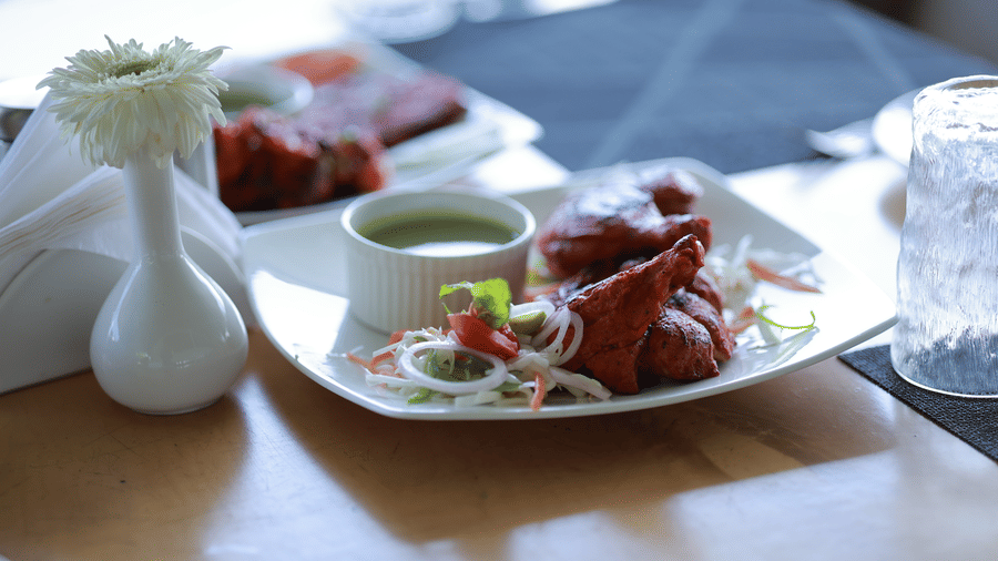 Close up of chicken tikka served with mint chutney along with onion rings at Machaan at Aveda Mountains and Mist Resort and Spa, Munnar.