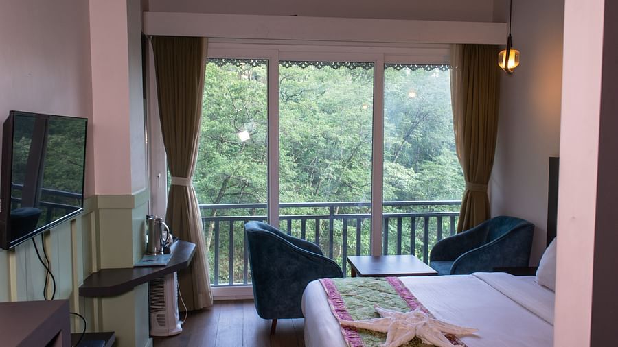 Image of premuim room with bed and sitting arrea overooking the lush greenery outside at  Avianna Ganagtok Resort and Spa