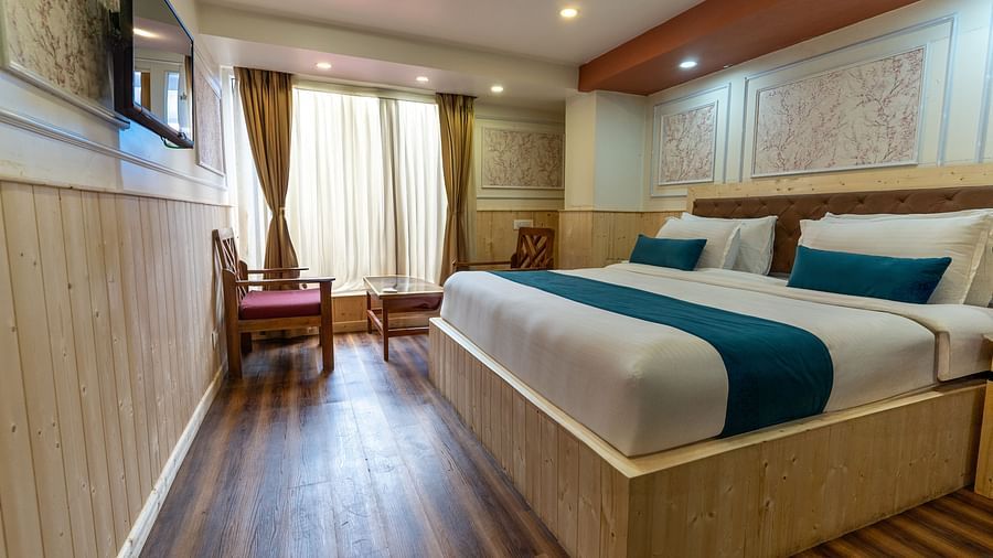 an image of a bedroom with natural light passing through the window at Avianna New Mandala Hotel & Spa, Darjeeling