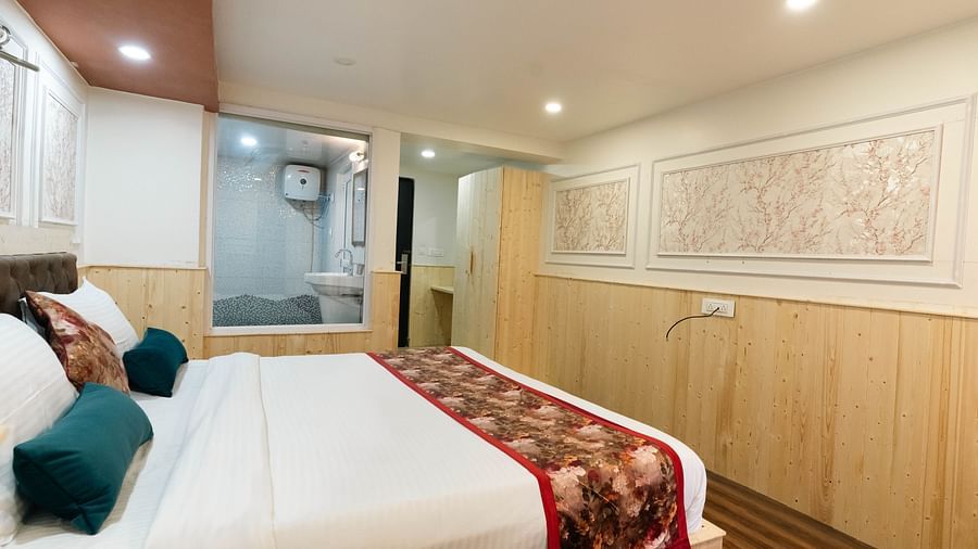 an image of a bedroom with wall decor and wooden strip flooring at an image of a bedroom with wooden strips flooring at Avianna New Mandala Hotel & Spa, Darjeeling.