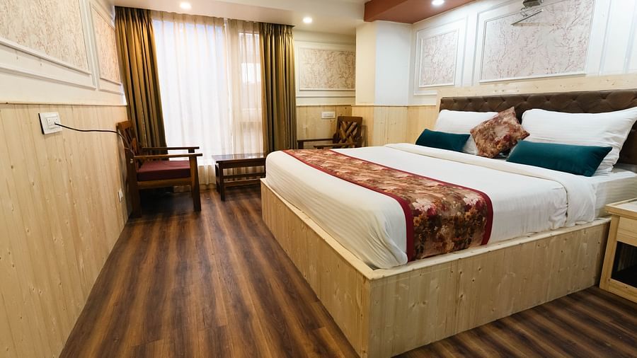 an image of a bedroom with wooden strips flooring at Avianna New Mandala Hotel & Spa, Darjeeling