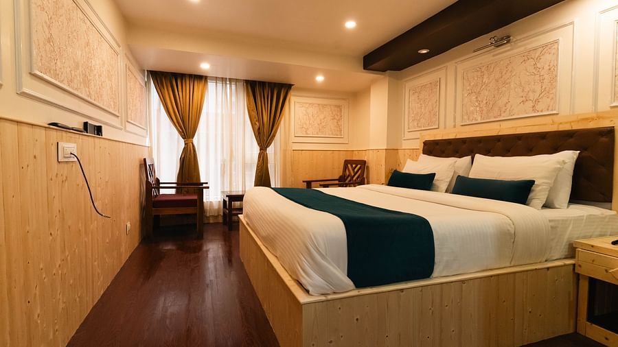 an image of a bedroom with a window covered by curtains at Avianna New Mandala Hotel & Spa, Darjeeling.