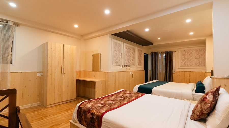 an image of a family room with two beds and wooden finished wardrobe at Avianna New Mandala Hotel & Spa, Darjeeling