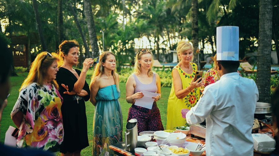 A group of women looking at a chef who is conducting a workshop on cooking at Ayur On The Beach Nattika.