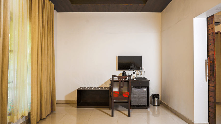 A minimalist workspace with a desk and chair inside a guest room at Ayur On The Beach Nattika.
