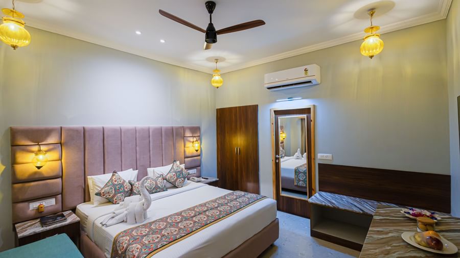 A wide view of a room with a large bed, dressing table, and ample floor space at Bamboo Saa Resort & Spa, Udaipur.