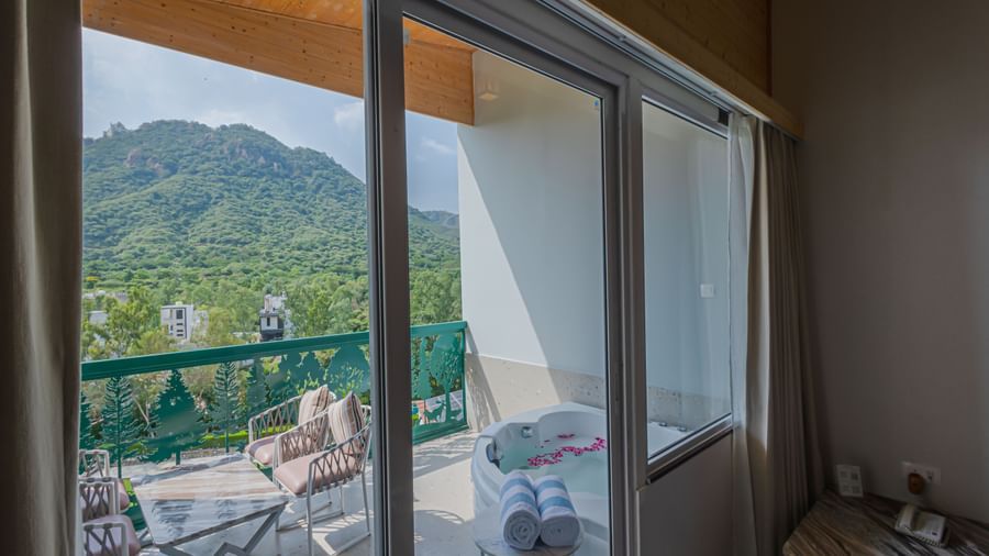 A view of the balcony from Sajjan Villa at Bamboo Saa Resort and Spa, Udaipur showcasing seating area and a jacuzzi.