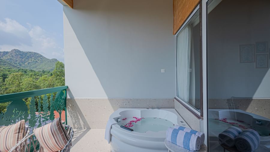 Sajjan Villa balcony featuring a seating area and a Jacuzzi with views of hills at Bamboo Saa Resorts and Spa, Udaipur.