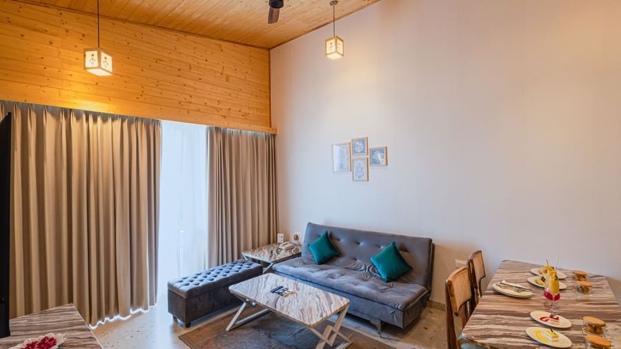 Sajjan Villa at Bamboo Saa Resorts and Spa, Udaipur featuring a seating area with sofa, chairs, and centre table and a dining space.