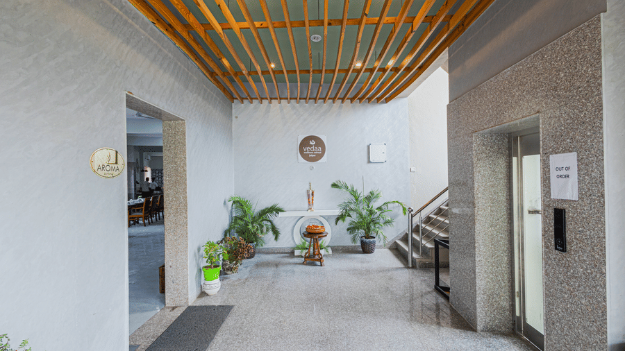 Bamboo Saa Sunrise Wedding & Wellness Resort, Jaipur entrance with a staircase, potted plants, wooden ceiling, and open passageway.