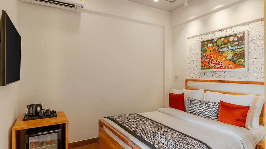Cosy hotel room with a double bed and wall-mounted TV at Bedzzz Xclusiv Morjim, Goa