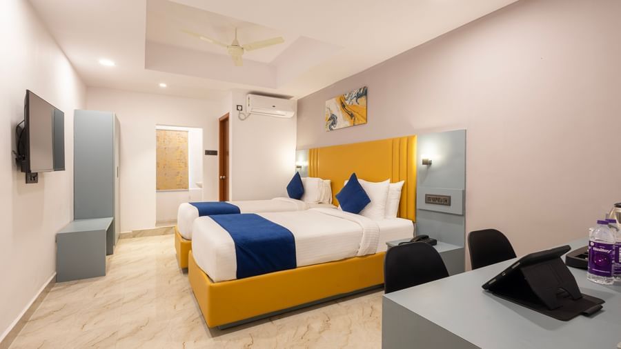 Superior Room featuring a bed with blue and white bedding, a yellow headboard, and modern furnishings including a desk and TV - Beestay Hotel Financial District, Hyderabad