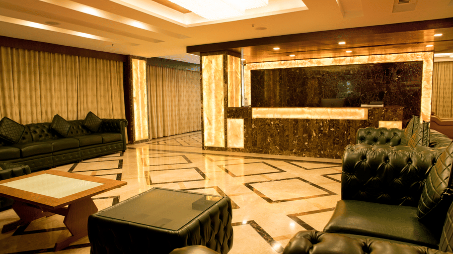 A hotel lobby at Benzz Park Chennai with comfortable seating areas, stylish decor, and ornate flooring.