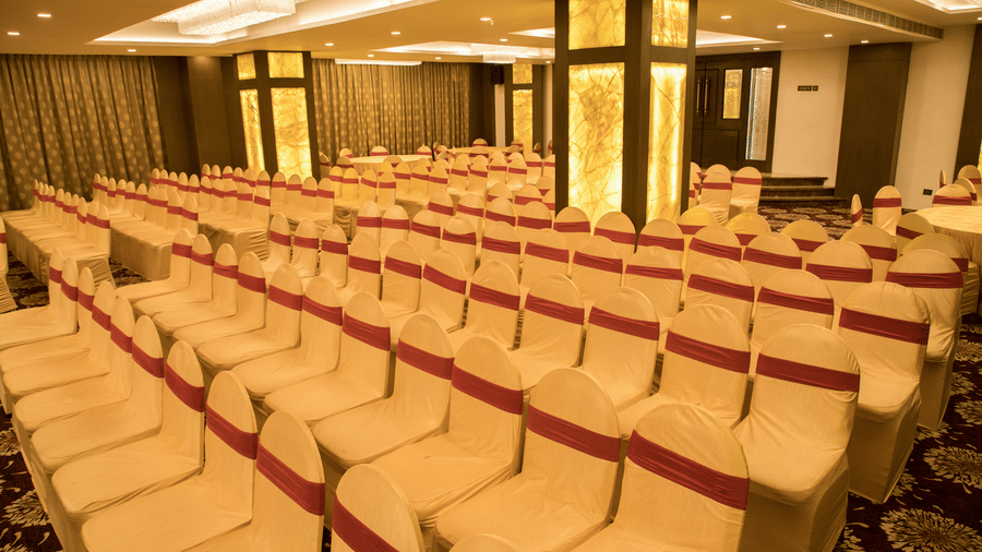 A spacious event hall at Benzz Park Chennai filled with neat rows of chairs, ready for a large gathering or conference.
