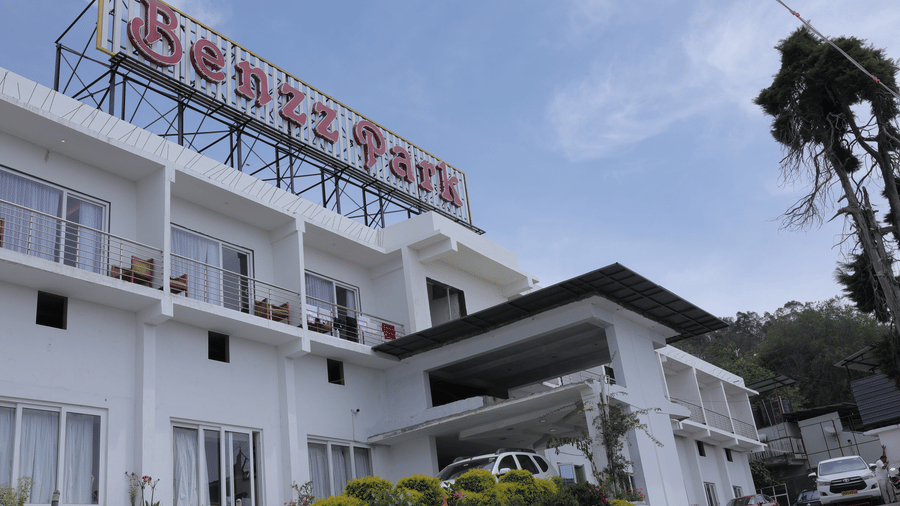 The exterior of Benzz Park, Kodaikanal hotel building under a clear sky.