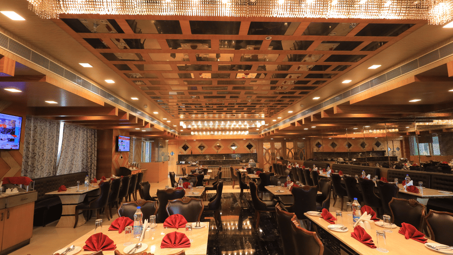 Full view of the Porchae multi-cuisine restaurant with warm lighting and well-arranged dining tables at Benzz Park, Vellore.