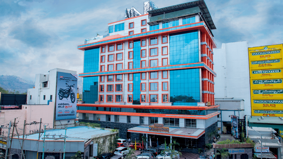 Facade shot of Benzz Park, Vellore, featuring the entrance on the bottom of the building along with a cloudy sky in the background.