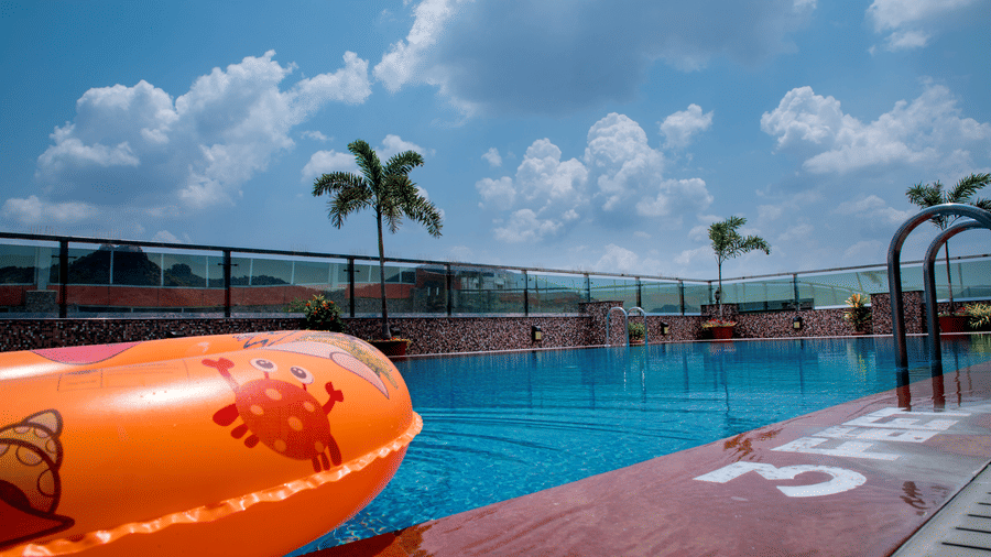 The rooftop swimming pool with an orange floating tube at the Benzz Park, Vellore.