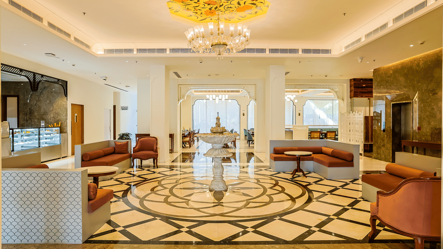 Spacious luxury lobby featuring comfortable seating arrangements, patterned marble flooring, and a central fountain at Bhagirathi by Atishay.