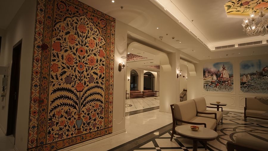 The reception area at Bhagirathi by RDB Atishay with warm lighting and intricate paintings on the walls.