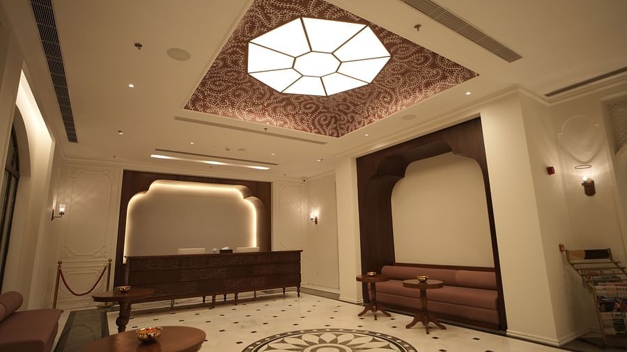 An expansive lobby area at Bhagirathi by RDB Atishay with an atrium on the ceiling featuring intricate patterns painted on it.