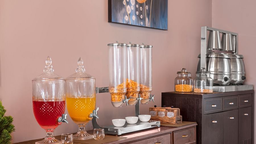 Self-serve breakfast counter with juice dispensers, cereals, and tea set-up, at BluSalzz Collection - Suvaasa Resort, Ramgarh.