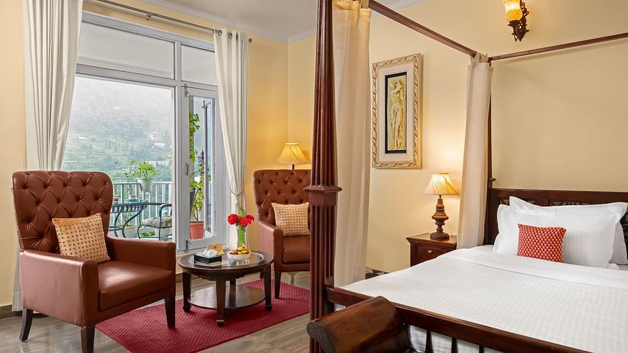 Elegant bedroom with a cosy seating area and a mountain-view balcony at BluSalzz Collection - Suvaasa Resort, Ramgarh.
