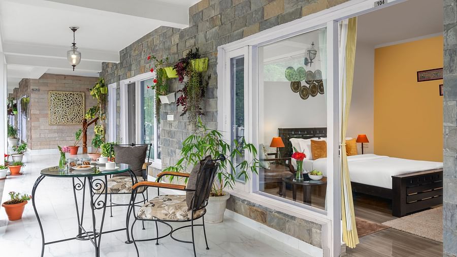 Stylish outdoor seating area with plants and a partial view of the room interior, at BluSalzz Collection - Suvaasa Resort, Ramgarh.