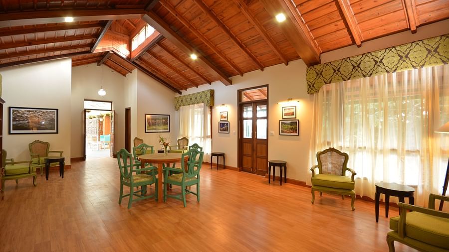 A brightly-lit hall in Almora with vintage-style furnishings and large windows - BluSalzz Escapade - Anant Rasa Resort