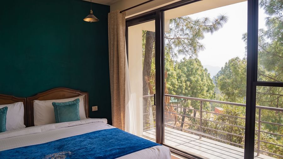 A bedroom with a light hanging from the ceiling and a balcony at BluSalzz Escapade Resort, Lansdowne