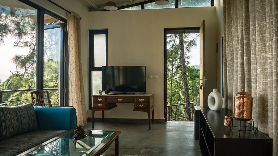 A living room featuring sofas, a table, and a television at BluSalzz Escapade Resort, Lansdowne