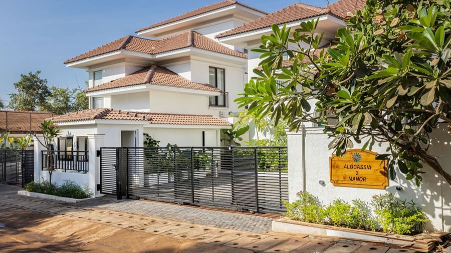 A side view of a modern villa with a landscaped garden, gated entrance, and stylish design elements - BluSalzz Villas - Alocassia, Anjuna