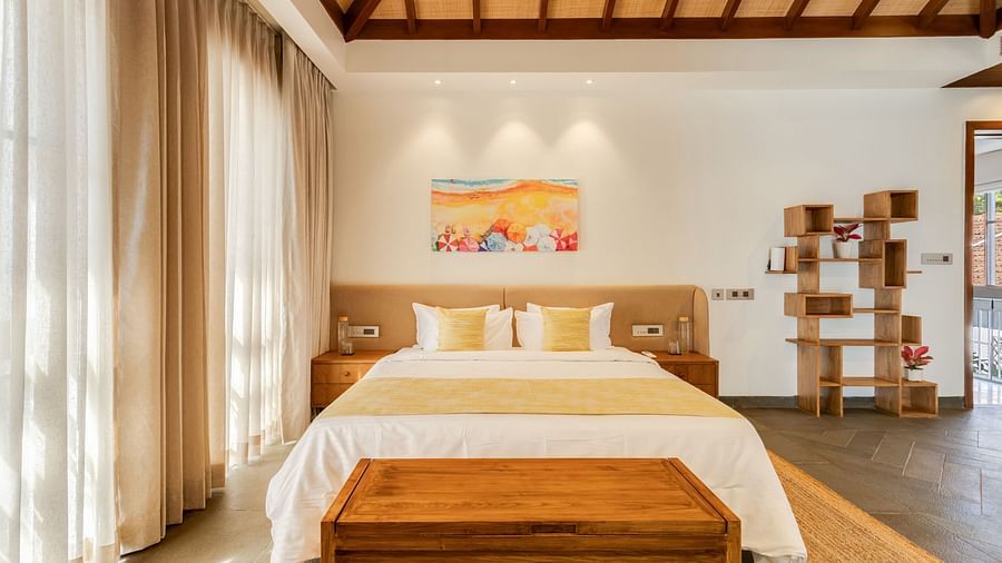 A spacious bedroom with a pitched wooden ceiling, a king-sized bed, and large windows framed with sheer curtains - BluSalzz Villas - Alocassia, Anjuna