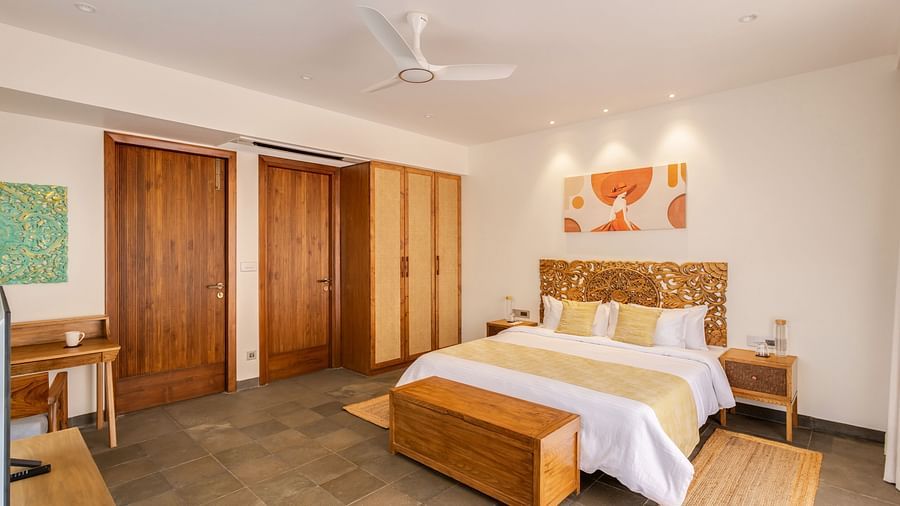 A bright bedroom showcasing a king-sized bed, ample wooden storage, and elegant decor complemented by natural light - BluSalzz Villas - Alocassia, Anjuna