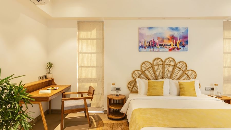 A bedroom with a well-designed work desk, a king-sized bed, and elegant decor accented by green plants and wall art - BluSalzz Villas - Alocassia, Anjuna